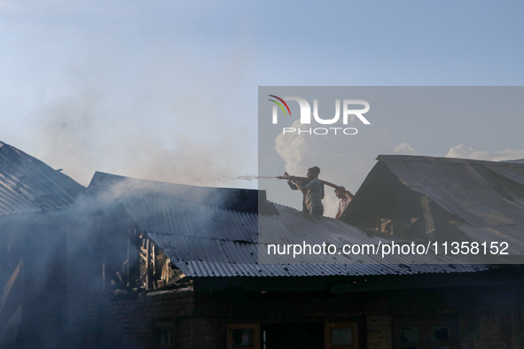 People are trying to douse the fire in a congested neighborhood in Old City Srinagar, Indian Administered Kashmir, on June 24, 2024. Several...