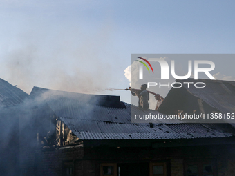 People are trying to douse the fire in a congested neighborhood in Old City Srinagar, Indian Administered Kashmir, on June 24, 2024. Several...