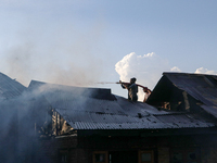 People are trying to douse the fire in a congested neighborhood in Old City Srinagar, Indian Administered Kashmir, on June 24, 2024. Several...