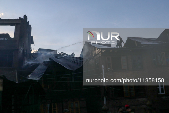 People are trying to douse the fire in a congested neighborhood in Old City Srinagar, Indian Administered Kashmir, on June 24, 2024. Several...