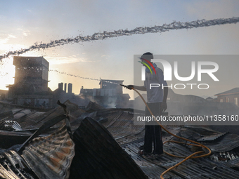 People are trying to douse the fire in a congested neighborhood in Old City Srinagar, Indian Administered Kashmir, on June 24, 2024. Several...