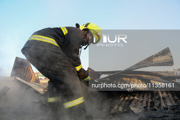 A firefighter is clearing debris inside a damaged building after a fire engulfed a congested neighborhood in Old City Srinagar, Indian Admin...