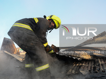 A firefighter is clearing debris inside a damaged building after a fire engulfed a congested neighborhood in Old City Srinagar, Indian Admin...