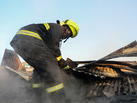 A firefighter is clearing debris inside a damaged building after a fire engulfed a congested neighborhood in Old City Srinagar, Indian Admin...