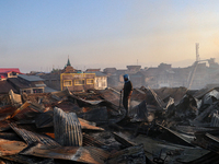 People are clearing the debris inside a damaged building after a fire engulfed a congested neighborhood in Old City Srinagar, Indian Adminis...