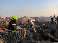 People are clearing the debris inside a damaged building after a fire engulfed a congested neighborhood in Old City Srinagar, Indian Adminis...