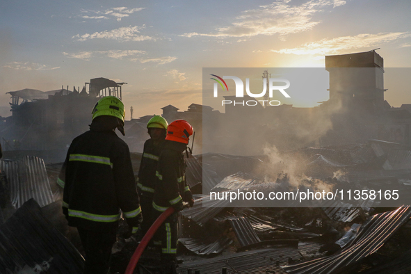 Firefighters are trying to douse the fire in a congested neighborhood in Old City Srinagar, Indian Administered Kashmir, on June 24, 2024. S...