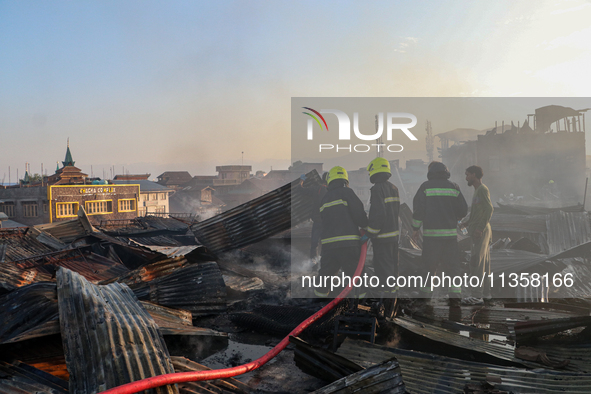 Firefighters are trying to douse the fire in a congested neighborhood in Old City Srinagar, Indian Administered Kashmir, on June 24, 2024. S...