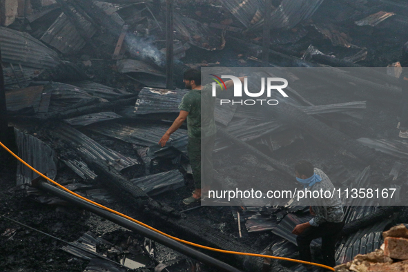 People are clearing the debris inside a damaged building after a fire engulfed a congested neighborhood in Old City Srinagar, Indian Adminis...