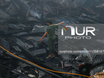 People are clearing the debris inside a damaged building after a fire engulfed a congested neighborhood in Old City Srinagar, Indian Adminis...