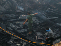 People are clearing the debris inside a damaged building after a fire engulfed a congested neighborhood in Old City Srinagar, Indian Adminis...