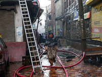 A woman is running for safety after a fire is engulfing a congested neighborhood in Old City Srinagar, Indian Administered Kashmir, on June...