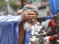 A rickshaw puller is splashing water on his face to get relief on a hot summer day in Dhaka, Bangladesh, on June 24, 2024. (