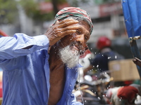 A rickshaw puller is splashing water on his face to get relief on a hot summer day in Dhaka, Bangladesh, on June 24, 2024. (