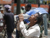 A thirsty rickshaw puller is drinking water to get relief on a hot summer day in Dhaka, Bangladesh, on June 24, 2024. (