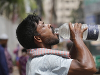 A thirsty rickshaw puller is drinking water to get relief on a hot summer day in Dhaka, Bangladesh, on June 24, 2024. (