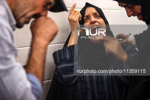 A mourner is reacting next to the bodies of Palestinians killed in Israeli strikes, amid the Israel-Hamas conflict, at Al-Aqsa hospital in D...