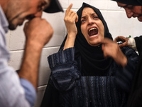 A mourner is reacting next to the bodies of Palestinians killed in Israeli strikes, amid the Israel-Hamas conflict, at Al-Aqsa hospital in D...