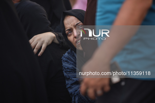 A mourner is reacting during the funeral of Palestinians killed in Israeli strikes, amid the Israel-Hamas conflict, at Al-Aqsa hospital in D...