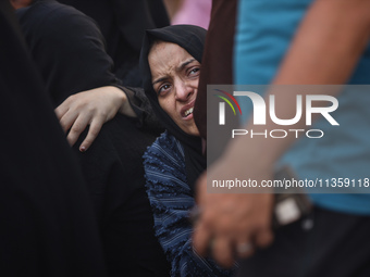 A mourner is reacting during the funeral of Palestinians killed in Israeli strikes, amid the Israel-Hamas conflict, at Al-Aqsa hospital in D...