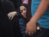 A mourner is reacting during the funeral of Palestinians killed in Israeli strikes, amid the Israel-Hamas conflict, at Al-Aqsa hospital in D...