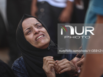 A mourner is reacting during the funeral of Palestinians killed in Israeli strikes, amid the Israel-Hamas conflict, at Al-Aqsa hospital in D...