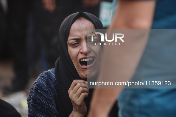 A mourner is reacting during the funeral of Palestinians killed in Israeli strikes, amid the Israel-Hamas conflict, at Al-Aqsa hospital in D...