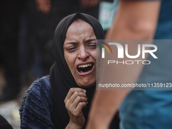 A mourner is reacting during the funeral of Palestinians killed in Israeli strikes, amid the Israel-Hamas conflict, at Al-Aqsa hospital in D...