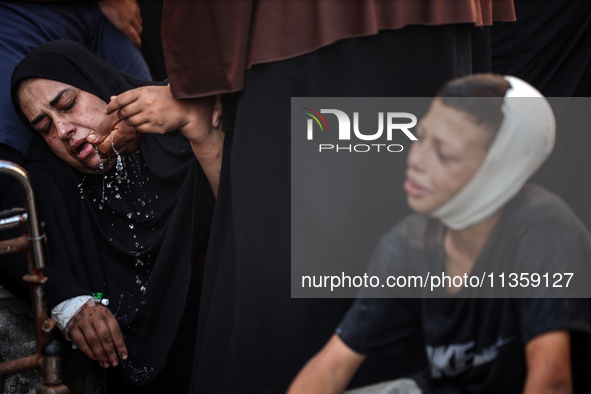 Mourners are reacting during the funeral of Palestinians killed in Israeli strikes, amid the Israel-Hamas conflict, at Al-Aqsa hospital in D...