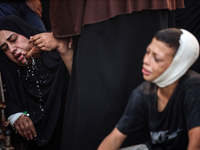 Mourners are reacting during the funeral of Palestinians killed in Israeli strikes, amid the Israel-Hamas conflict, at Al-Aqsa hospital in D...