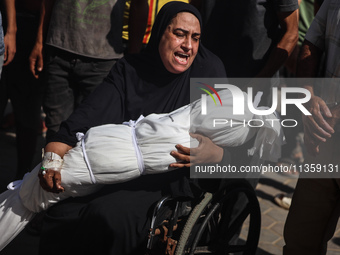 A mourner is reacting next to the bodies of Palestinians killed in Israeli strikes, amid the Israel-Hamas conflict, at Al-Aqsa hospital in D...