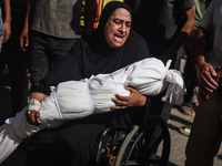 A mourner is reacting next to the bodies of Palestinians killed in Israeli strikes, amid the Israel-Hamas conflict, at Al-Aqsa hospital in D...