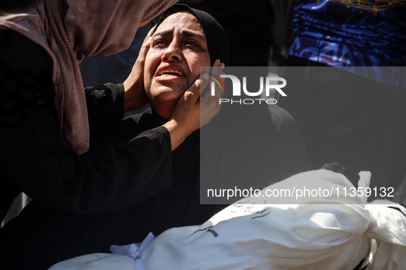 A mourner is reacting next to the bodies of Palestinians killed in Israeli strikes, amid the Israel-Hamas conflict, at Al-Aqsa hospital in D...