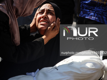 A mourner is reacting next to the bodies of Palestinians killed in Israeli strikes, amid the Israel-Hamas conflict, at Al-Aqsa hospital in D...