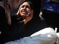 A mourner is reacting next to the bodies of Palestinians killed in Israeli strikes, amid the Israel-Hamas conflict, at Al-Aqsa hospital in D...