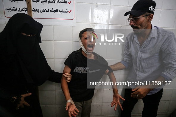 A mourner is reacting next to the bodies of Palestinians killed in Israeli strikes, amid the Israel-Hamas conflict, at Al-Aqsa hospital in D...