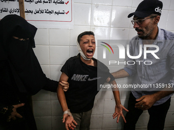 A mourner is reacting next to the bodies of Palestinians killed in Israeli strikes, amid the Israel-Hamas conflict, at Al-Aqsa hospital in D...