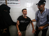 A mourner is reacting next to the bodies of Palestinians killed in Israeli strikes, amid the Israel-Hamas conflict, at Al-Aqsa hospital in D...