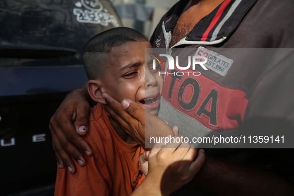 A mourner is reacting during the funeral of Palestinians killed in Israeli strikes, amid the Israel-Hamas conflict, at Al-Aqsa hospital in D...