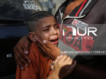 A mourner is reacting during the funeral of Palestinians killed in Israeli strikes, amid the Israel-Hamas conflict, at Al-Aqsa hospital in D...