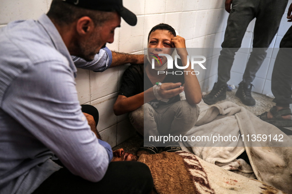 A mourner is reacting next to the bodies of Palestinians killed in Israeli strikes, amid the Israel-Hamas conflict, at Al-Aqsa hospital in D...