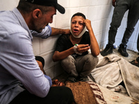 A mourner is reacting next to the bodies of Palestinians killed in Israeli strikes, amid the Israel-Hamas conflict, at Al-Aqsa hospital in D...