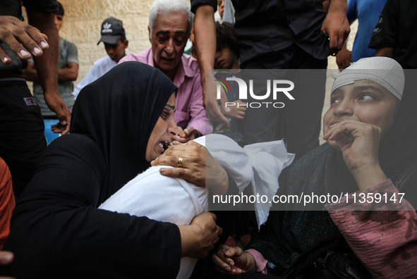 Mourners are reacting next to the bodies of Palestinians killed in Israeli strikes, amid the Israel-Hamas conflict, at Al-Aqsa hospital in D...