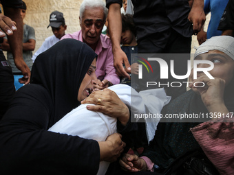 Mourners are reacting next to the bodies of Palestinians killed in Israeli strikes, amid the Israel-Hamas conflict, at Al-Aqsa hospital in D...