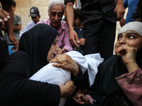 Mourners are reacting next to the bodies of Palestinians killed in Israeli strikes, amid the Israel-Hamas conflict, at Al-Aqsa hospital in D...