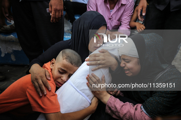 Mourners are reacting next to the bodies of Palestinians killed in Israeli strikes, amid the Israel-Hamas conflict, at Al-Aqsa hospital in D...