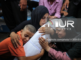 Mourners are reacting next to the bodies of Palestinians killed in Israeli strikes, amid the Israel-Hamas conflict, at Al-Aqsa hospital in D...