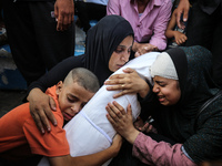 Mourners are reacting next to the bodies of Palestinians killed in Israeli strikes, amid the Israel-Hamas conflict, at Al-Aqsa hospital in D...