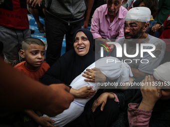 Mourners are reacting next to the bodies of Palestinians killed in Israeli strikes, amid the Israel-Hamas conflict, at Al-Aqsa hospital in D...