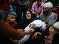 Mourners are reacting next to the bodies of Palestinians killed in Israeli strikes, amid the Israel-Hamas conflict, at Al-Aqsa hospital in D...